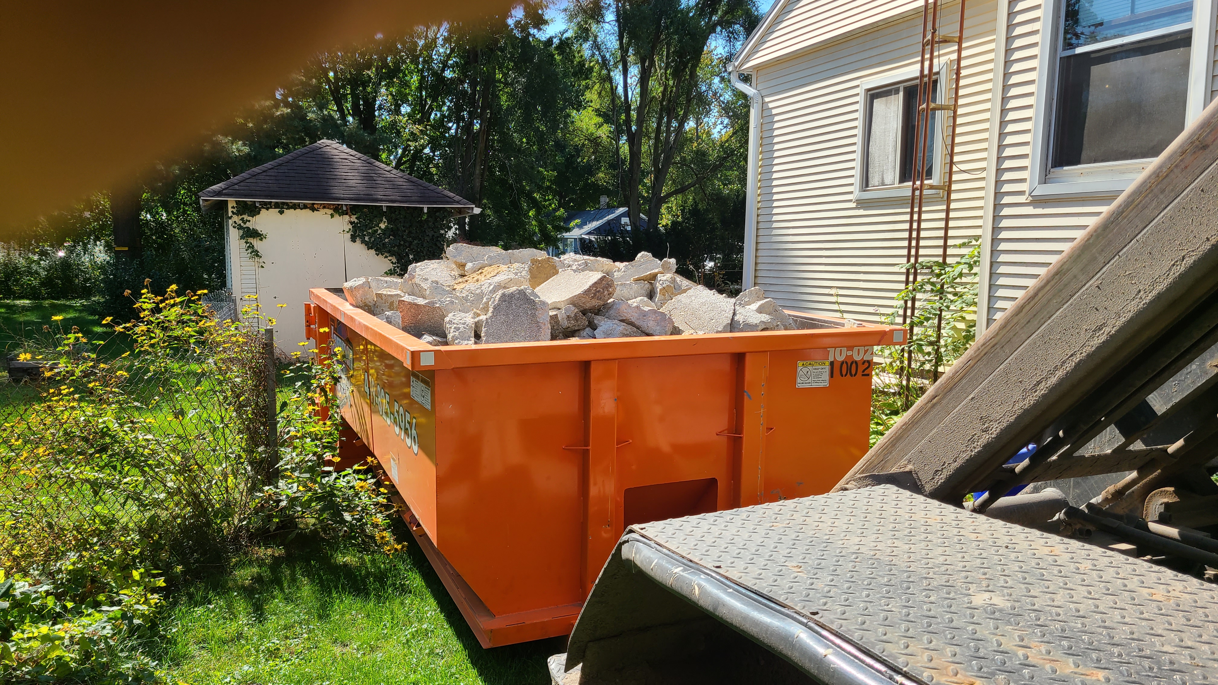Lammon Bros roll-off dumpster filled with broken concrete at a jobsite