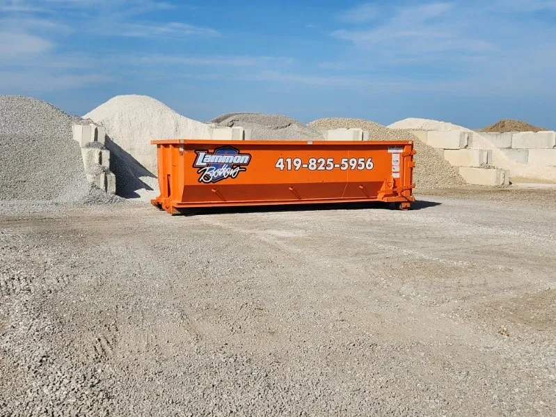 Orange Lammon Bros 15-yard roll-off dumpster with the 419-825-5956 number, staged at our Delta yard