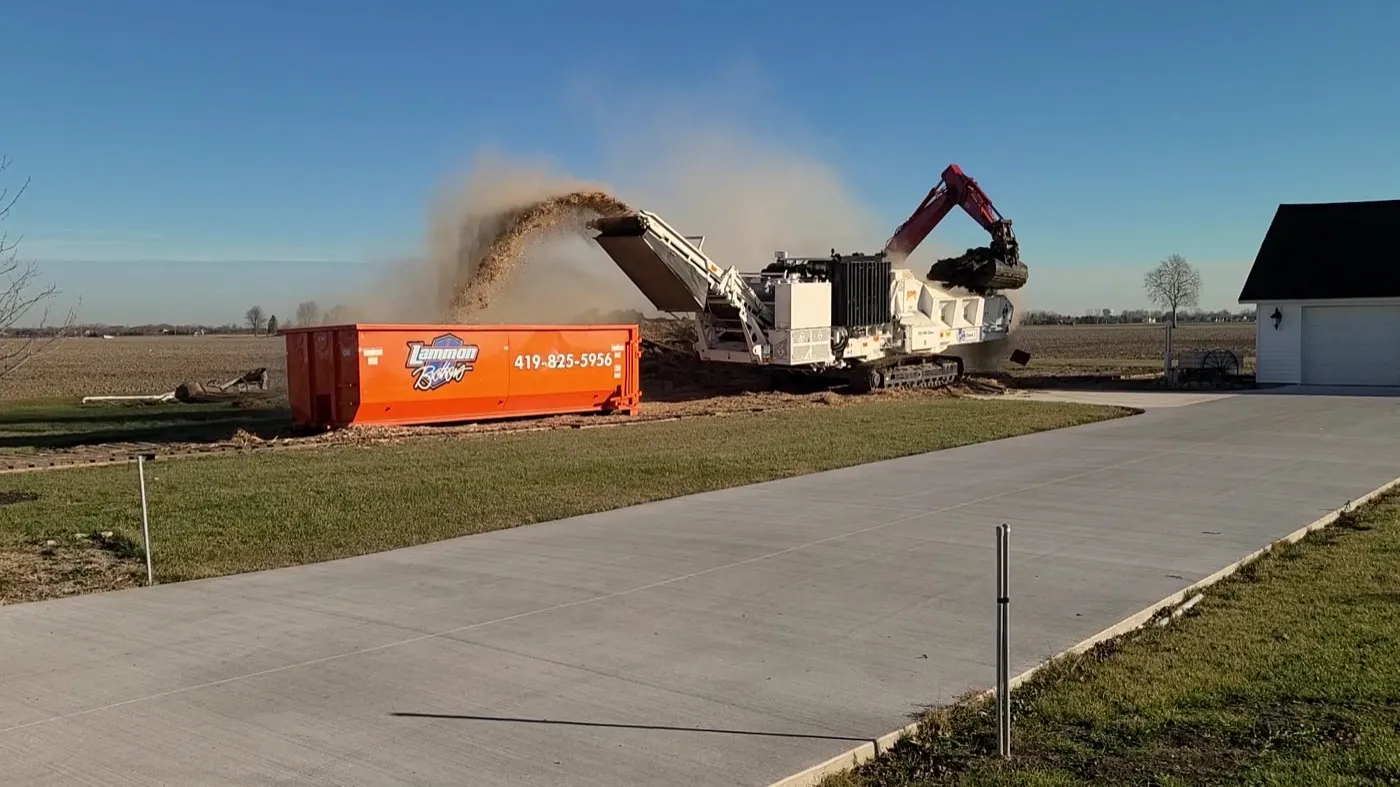 Tub grinder blowing ground wood into a mulch pile at the Lammon Bros yard