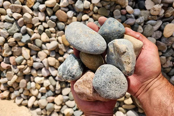Hands holding large rounded river rock